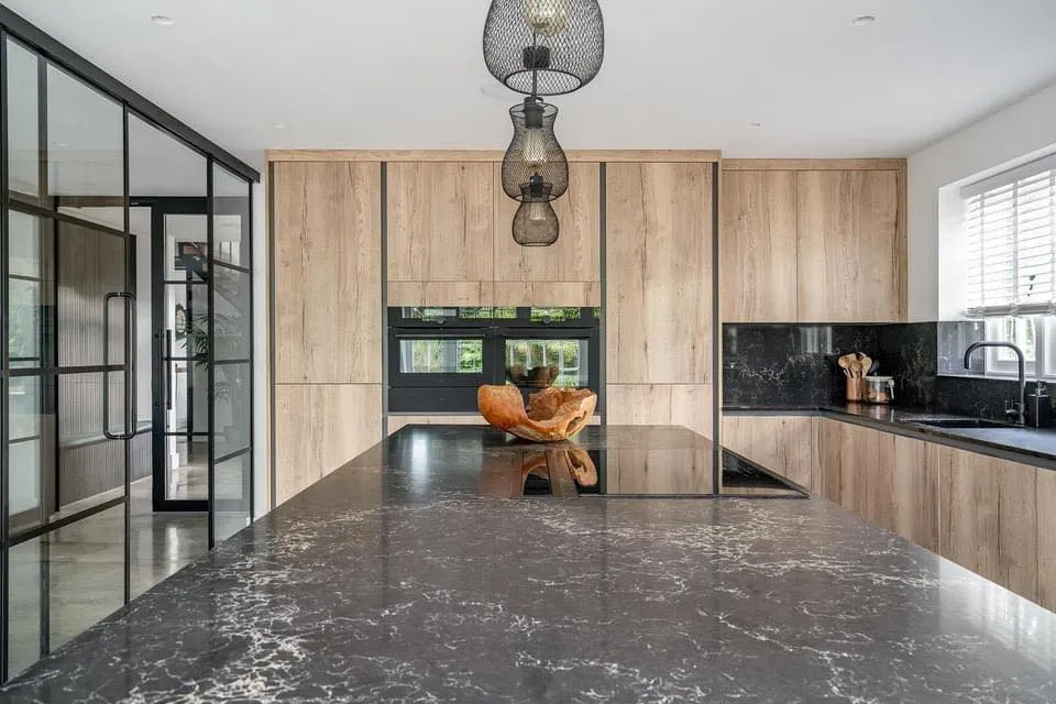 a kitchen with a marble counter top and wooden cabinets